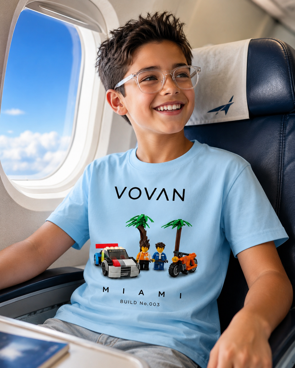 Child wearing a blue t-shirt with 'VOVAN' and 'Miami' design Lego t shirts build 003 on an airplane.
